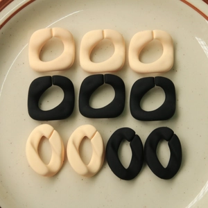 Nahaufnahme von matten Acryl-Verbindungsringen für DIY-Schmuck in Cremeweiß und Schwarz