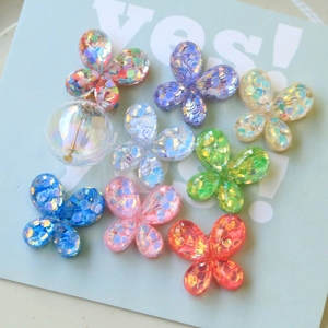 Detalle de dijes de mariposa de resina con lentejuelas para bisutería y accesorios de bricolaje