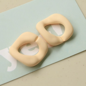Detailansicht matter geometrischer Acrylringe in Creme auf einer Displaykarte für Bastelprojekte