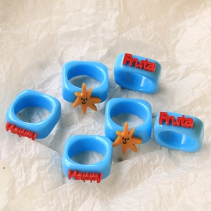 Sky blue acrylic rings featuring 3D Fruta and Happy lettering with sun icons