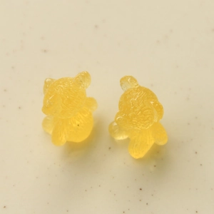 Close-up of translucent yellow resin bear charms with detailed texture for DIY crafts