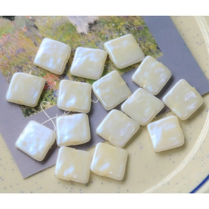 Détail macro de perles acryliques carrées crème nacrées avec texture pour bijoux DIY