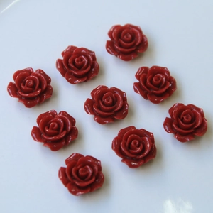 Detalle de nueve cabujones de rosas de resina roja para joyería DIY y accesorios de pelo