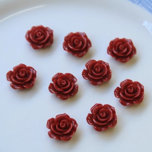 Vista macro detallada de nueve rosas de resina roja para joyería DIY en un cuenco blanco