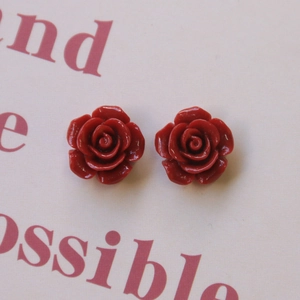 Detalle de dijes de flores de rosa de resina roja para joyas y accesorios DIY