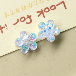 Detail of DIY flower charms with blue sequins inside transparent resin material