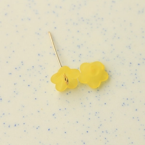 Detailed view of yellow frosted resin flower charms for DIY jewelry and hair accessories