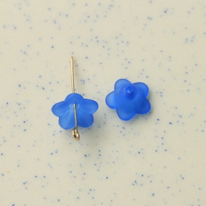 Macro shot of cobalt blue frosted resin flower beads with golden metal pin assembly