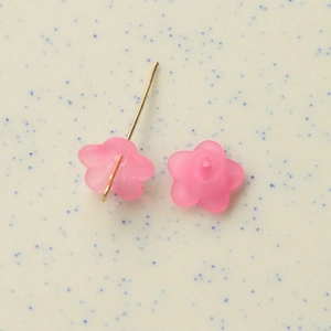 Macro shot of semi-transparent pink frosted flower resin charms with gold metal needles