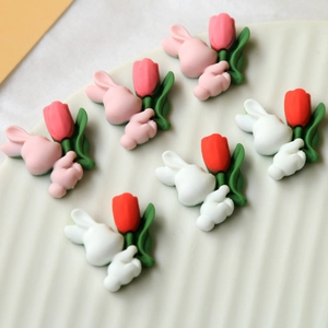 Detail of pink and white resin bunny figurines holding tulips for DIY crafts and decor