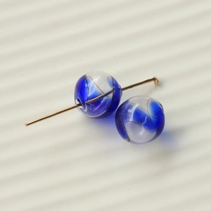 Detail showing 16mm blue spiral gradient glass bead on a golden metal jewelry pin