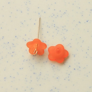 Detail of semi-transparent orange frosted resin flower charms for DIY jewelry making
