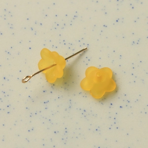 Macro detail of translucent frosted orange flower resin charms for DIY jewelry making