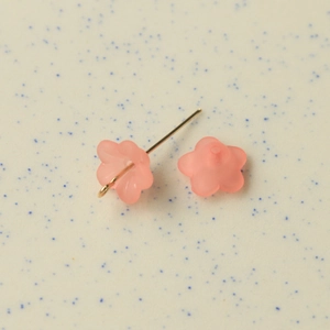 Detailed macro view of pink matte resin flower charms with golden metal eye pins