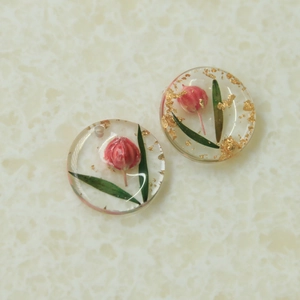Détail macro de breloques en résine avec boutons floraux séchés et feuilles d'or
