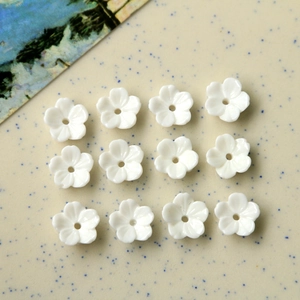 Détail macro de fleurs en résine blanche avec trou central pour la création de bijoux