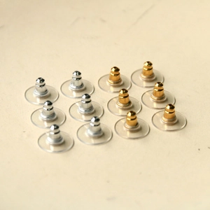 Detailed view of 12 pieces gold and silver metal core earring backs with clear pads