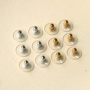 Detailed view of silver and gold bullet clutch earring backs with stabilizer discs