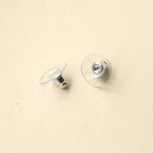 Macro view of silver bullet ear backings with transparent plastic disc support pads