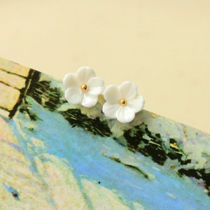 Boucles d'oreilles fleurs en résine blanche avec étamines dorées sur carte d'art