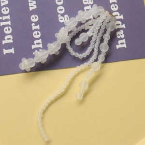 Detailopname van witte matte kralen en haarklem met kwastjes op luxe paarse achtergrond