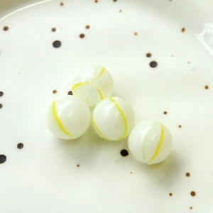 Macro-opname van 14mm glazen kralen met gele spiraalstrepen voor DIY-sieraden maken