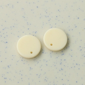 Nahaufnahme von 16mm cremefarbenen Acryl-Rundscheiben mit Löchern für DIY-Ohrringe