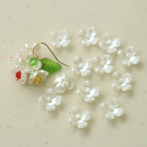 Macro shot of white acrylic orchid flower beads and DIY earring components for handmade jewelry