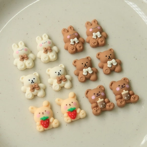 Flat lay of 12 cute resin cartoon bear and bunny DIY accessories on a ceramic plate