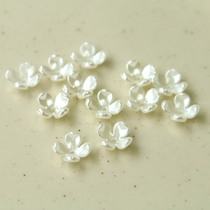 Detail of DIY pearl white four-petal flower charms for handmade jewelry making and crafts