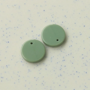 Nahaufnahme von 16mm Morandi-grünen runden Acryl-Anhängern mit Vorbohrungen für DIY-Schmuck