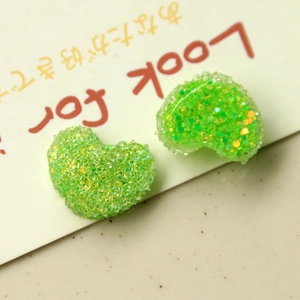 Dettaglio di cuori in resina verde glitterata per gioielli fai-da-te e accessori per capelli