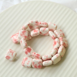 Close-up of pink cow print ceramic beads for DIY jewelry and handmade accessories