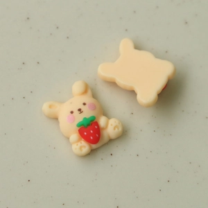 Detailed macro view of yellow resin cartoon rabbit with strawberry and smooth flat back