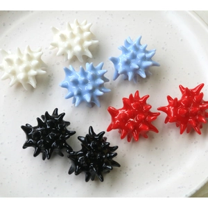 Close-up of colorful resin spiky heart beads in white, blue, red, and black for DIY crafts