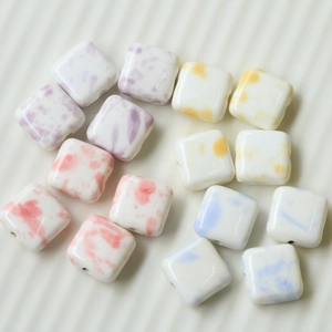 Detailed view of colorful ink-splash cow print square ceramic beads for DIY jewelry