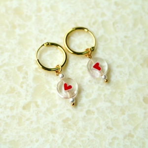Goldener Creolen-Ohrring mit Glaskugel, rotem Herzmuster und feinen Perlendetails