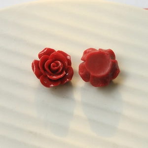 Macro detail of red resin rose charms showing both front petals and flat back base