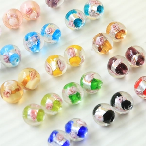 Handgefertigte bunte Glasperlen mit Silberfolie und rosa Blumenmuster für DIY Schmuck