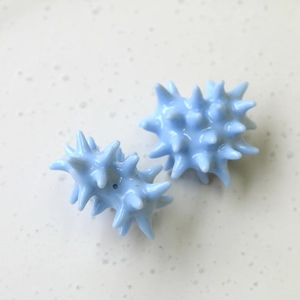 Macro view of light blue star-shaped resin beads for DIY earring and keychain crafts