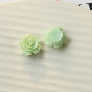 Macro detail showing front and flat back of light green resin rose DIY accessory flower