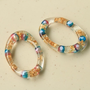 Orecchini a cerchio in resina irregolari con foglia d'oro e inserti di perle colorate