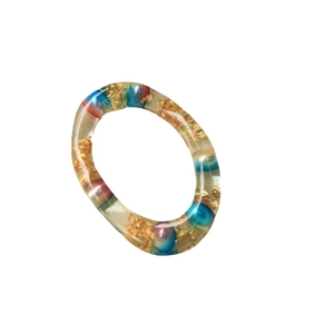 Anello in resina artistica con perle colorate e inserti in foglia d'oro su bianco