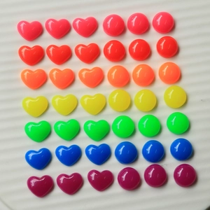 Flat lay of colorful 12mm resin heart and round flatback charms in neon gradient tones