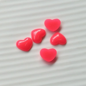 Detail of 5 pink resin heart patches for DIY nail art and mobile phone decoration