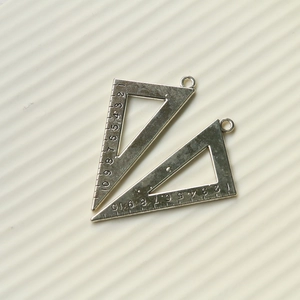 Detail of vintage silver triangular ruler charms with engraved numeric scale and top loop