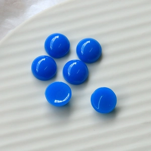 Macro shot of 12mm bright blue resin heart cabochons with a smooth polished finish