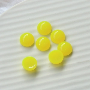 Flat lay of 12mm fluorescent yellow resin heart cabochons for DIY phone cases and jewelry