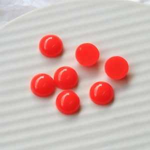 Close-up of 12mm fluorescent orange resin heart cabochons for DIY crafts and jewelry making