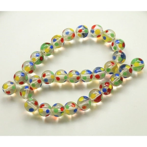Macro shot of clear glass beads with colorful rainbow polka dots for DIY jewelry making